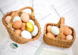 Две корзины с яйцами на фоне финансовых документов
